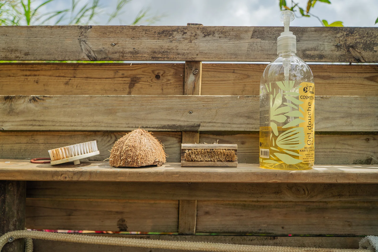 Gel douche, brosses et demi-coco sur l'étagère bois de la douche extérieure, Les Vendredis