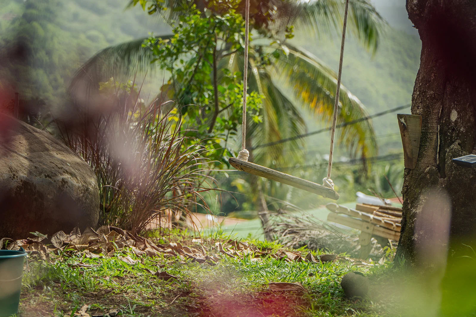 A wooden swing in the garden with the Sainte-Luce hills behind