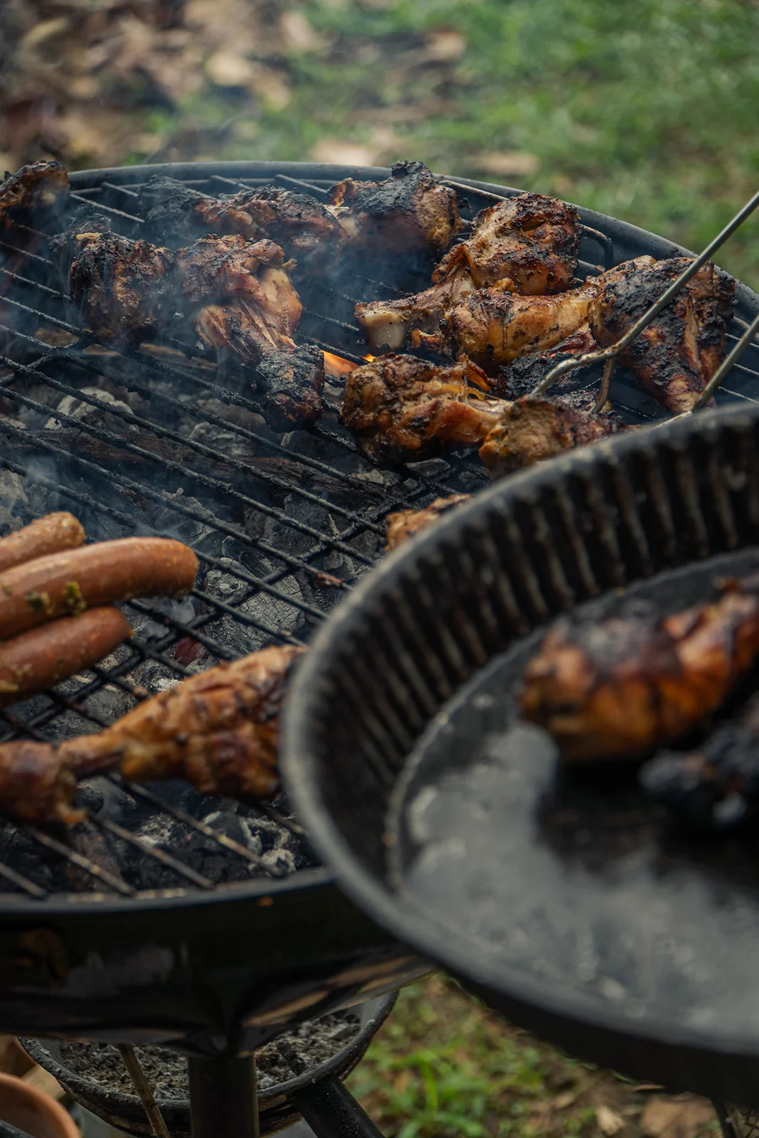 Grilled meat and sausages on the barbecue with smoke rising